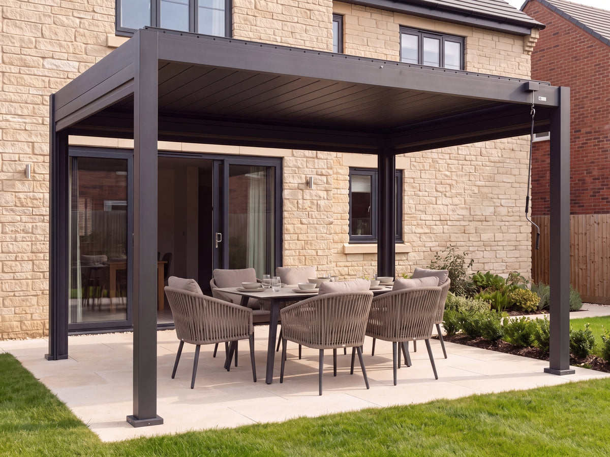 LuxSol Aura 3x4 · Open-sided dining hero · Closed roof and screens raised · Ceramic dining table and cushioned chairs with dark metal frames · Furniture shown for styling