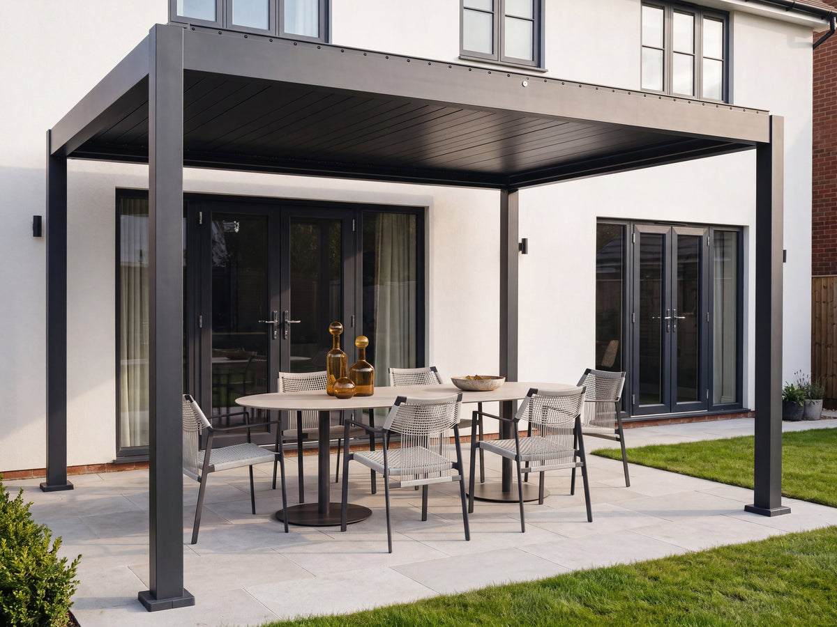 Como pergola with closed louvres and open sides over an outdoor dining table at a rendered house.