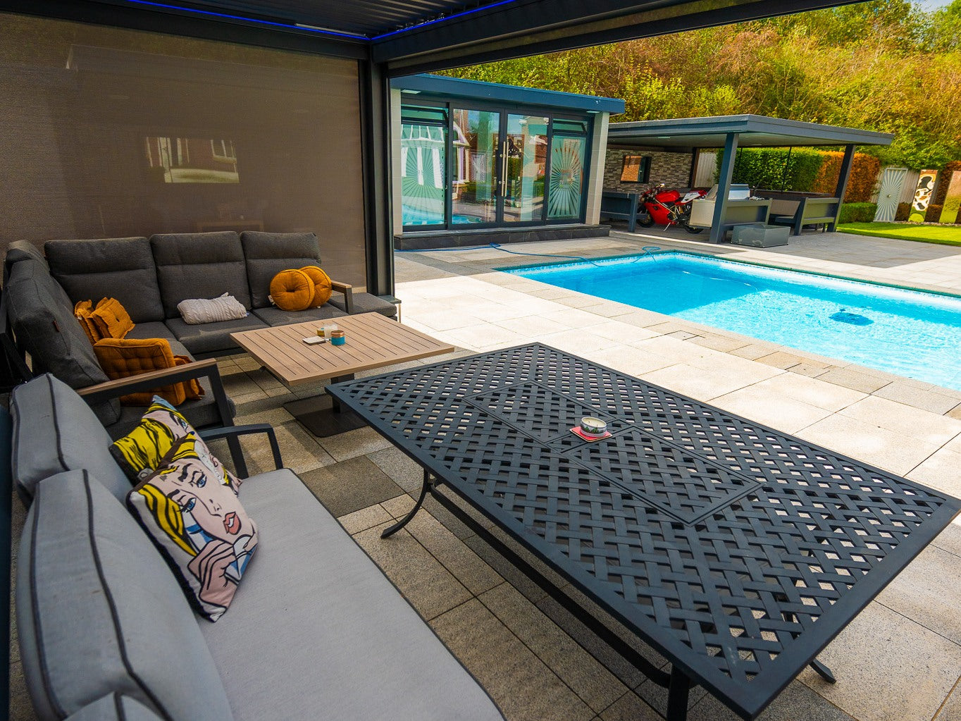 Real screen installation beside a furnished poolside seating area
