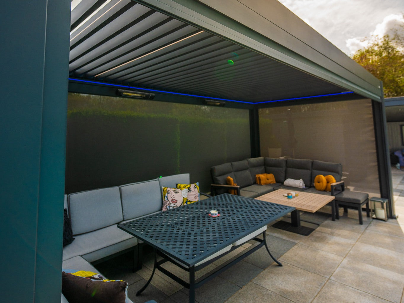 Real pergola seating area enclosed by lowered screens