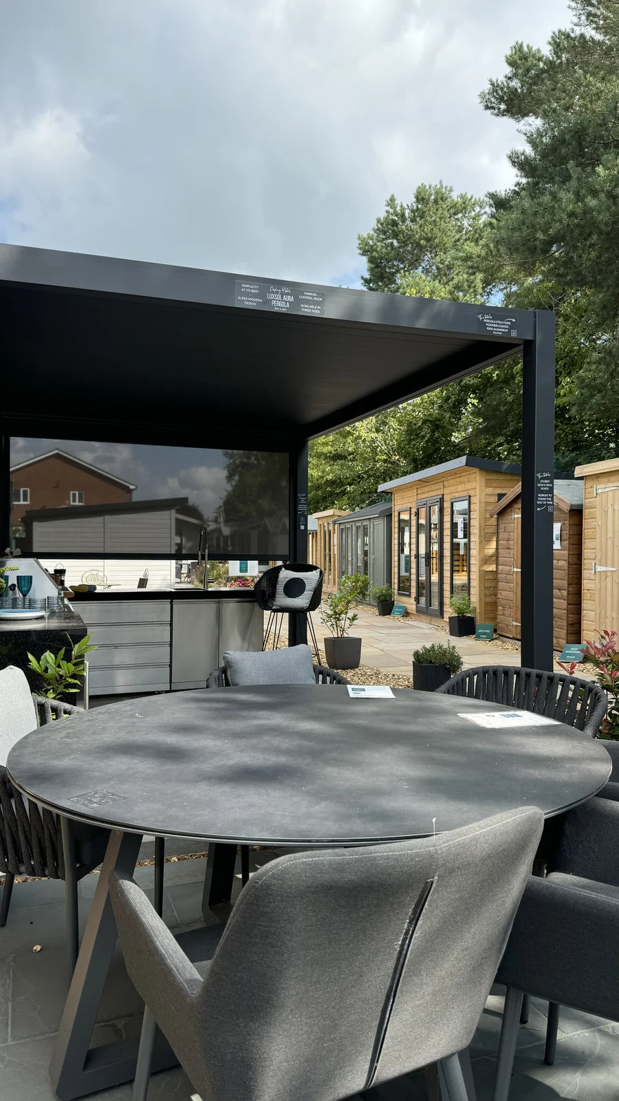The LuxSol Aura display at the Sandbach showroom, with a dining table beneath the louvred roof