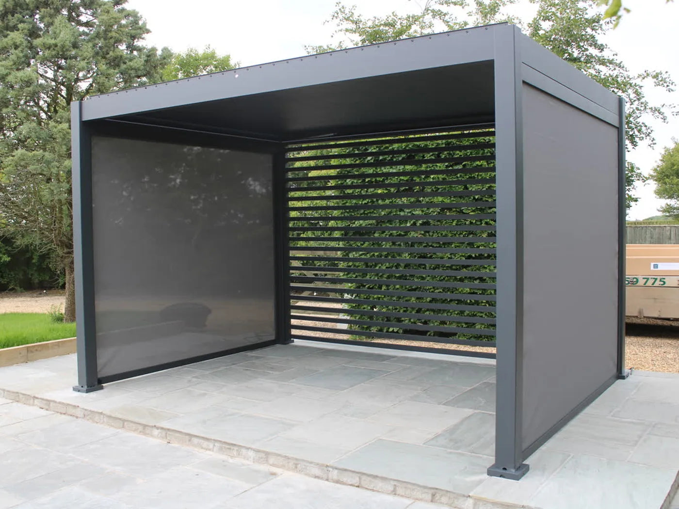 Como pergola with side screens and a slatted wall on a paved patio