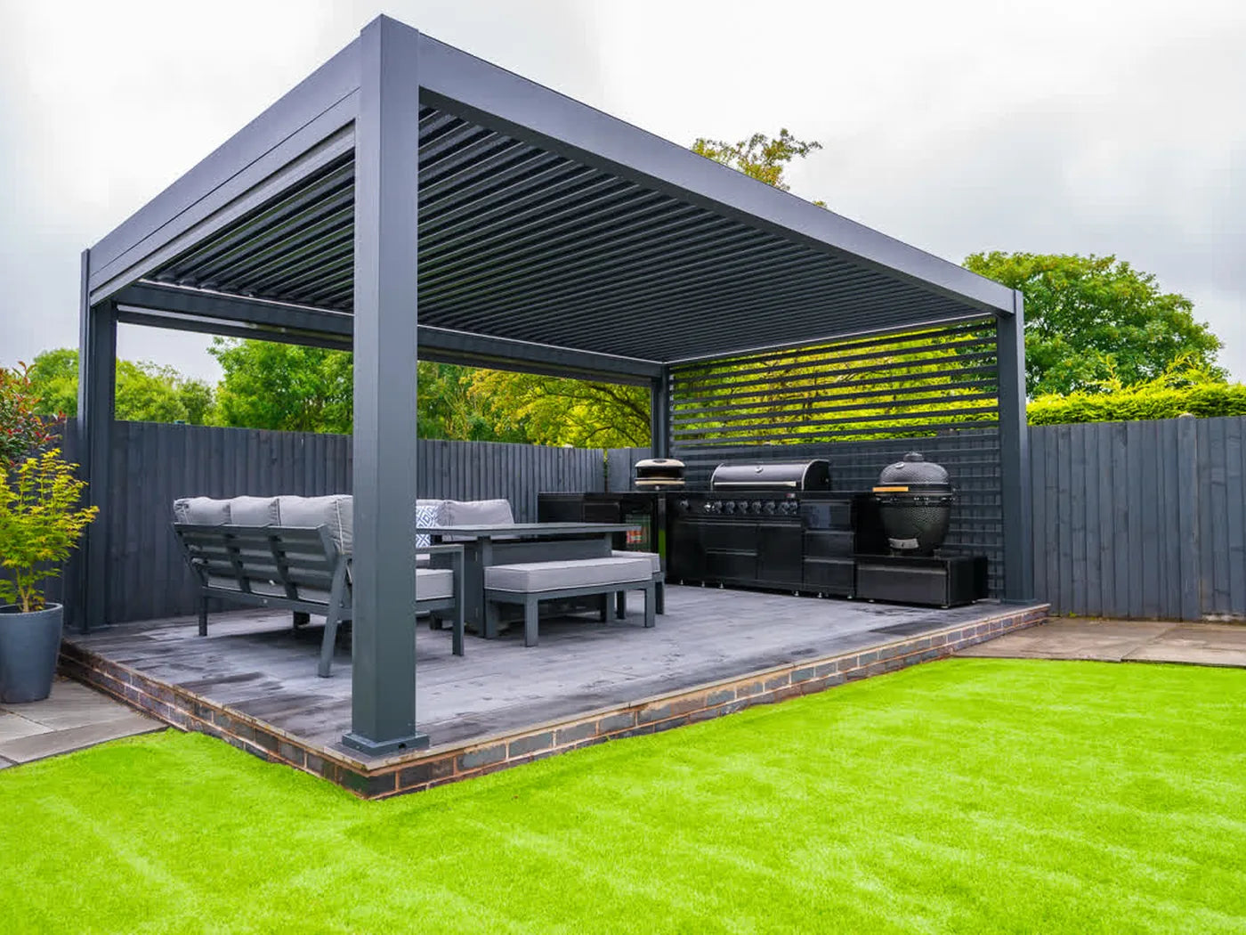 Tora pergola with lounge seating beside a green lawn