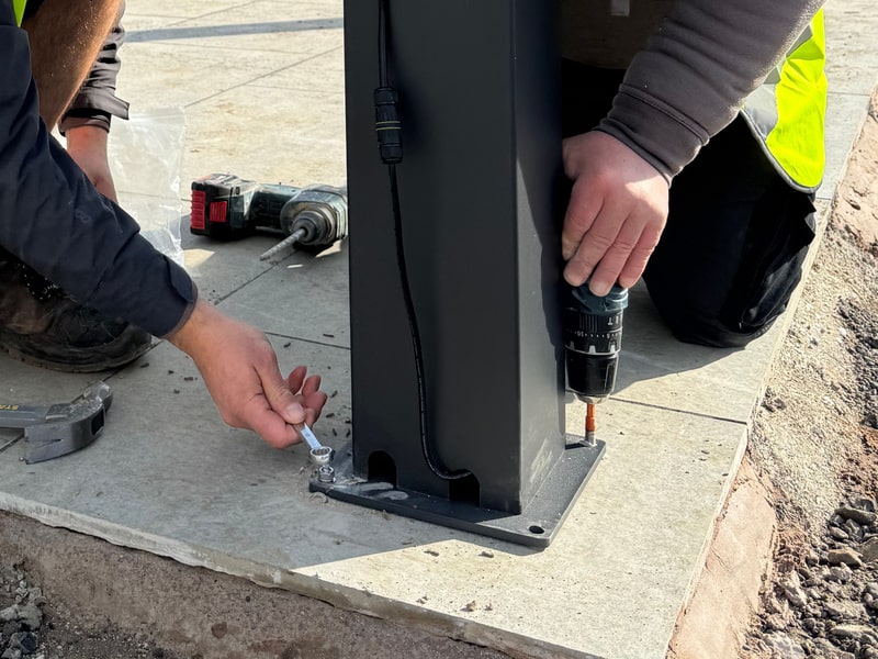 Two installers securing a LuxSol pergola post to its base
