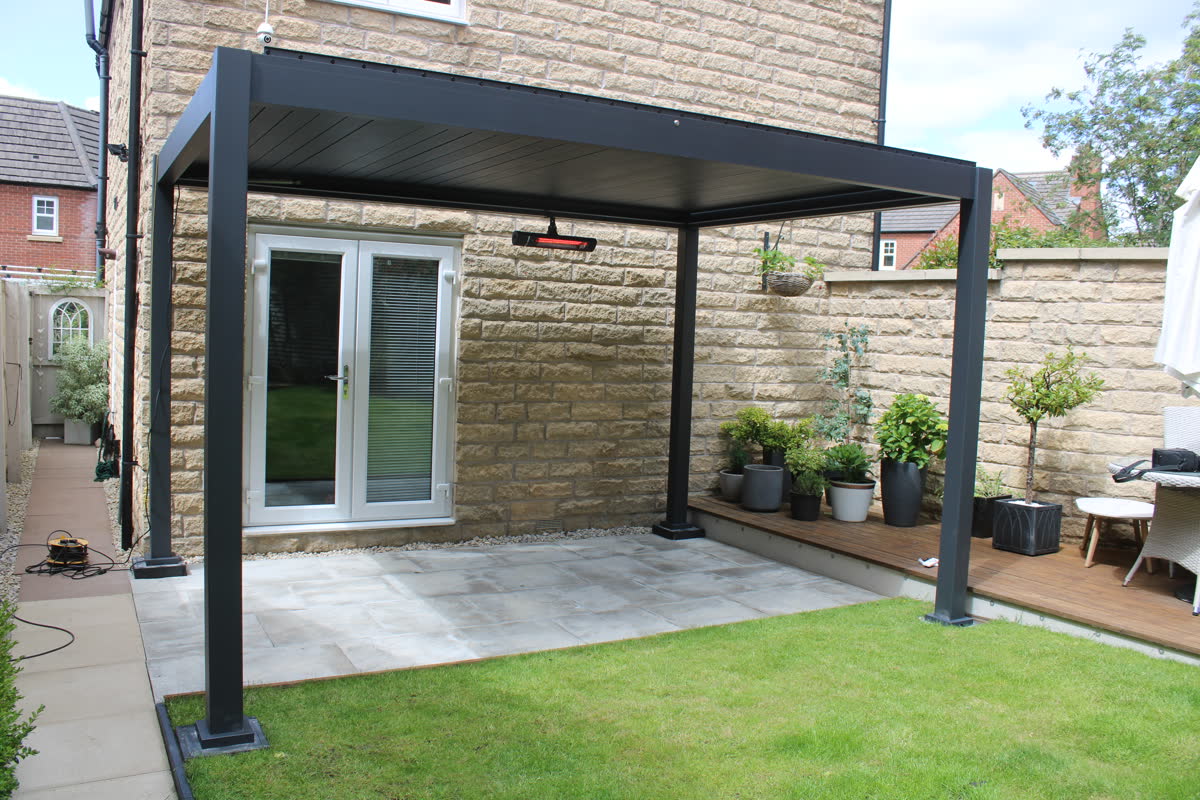 Como pergola on a patio beside a stone house